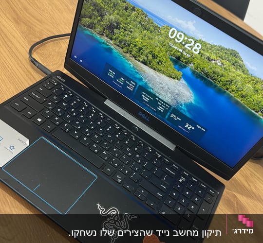 מחשב נייד דל על שולחן עץ עם מדבקות
